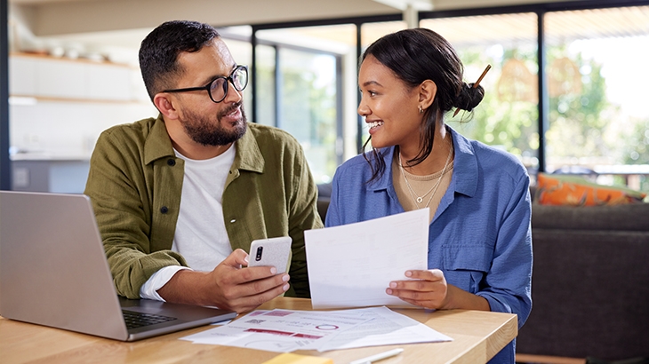 Couple reviewing finances at kitchen table.