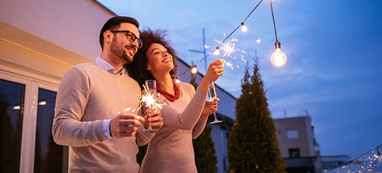 Couple celebrating New Year's with a sparkler.