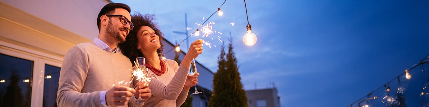 Couple celebrating New Year's with a sparkler.