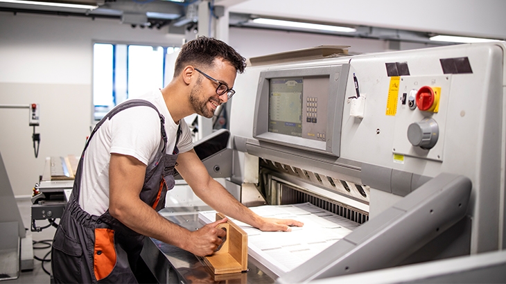 Man working with commercial printing machine.