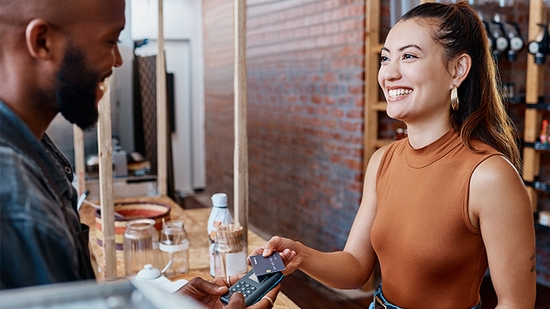 Woman checking out at a cafe with her credit card. 