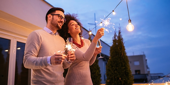 Couple celebrating New Year's with a sparkler.