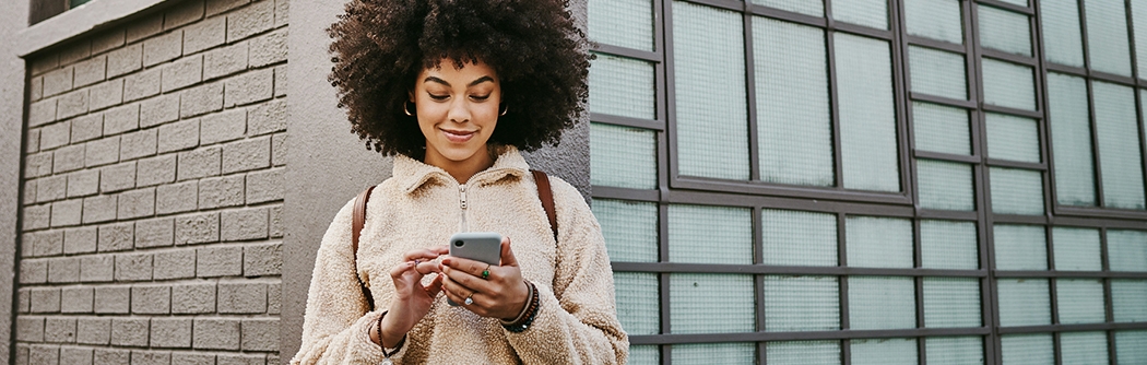 A young woman using WaFd Bank mobile app on her mobile phone.