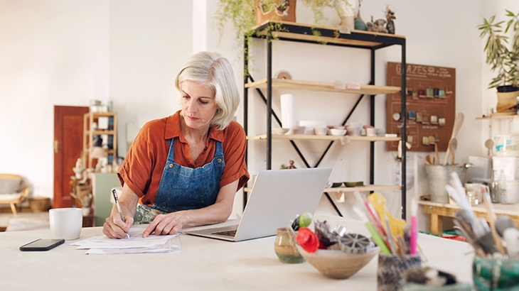 Ceramics shop owner working on her laptop.