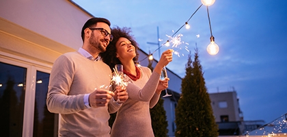 Couple celebrating New Year's with a sparkler.