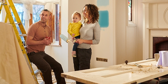 Una familia joven elige un nuevo color de pintura para su sala.