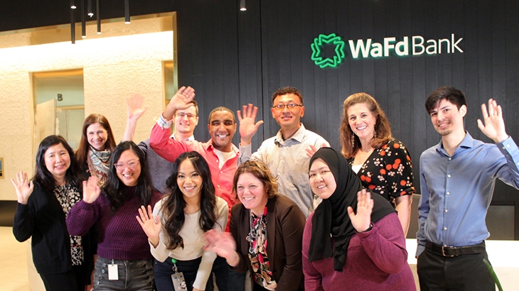 WaFd employees waving as a group in a WaFd Bank lobby