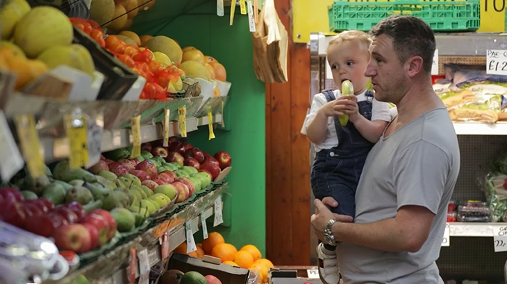 Father holding son in the grocery store.