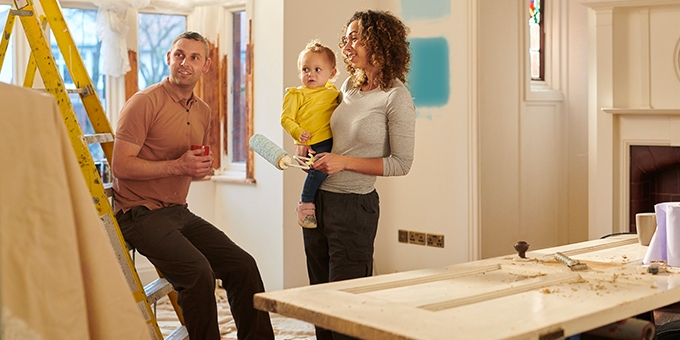 Una familia joven elige un nuevo color de pintura para su sala.