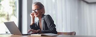 Business woman with laptop at desk in office.