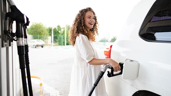 Woman filling car gas tank.