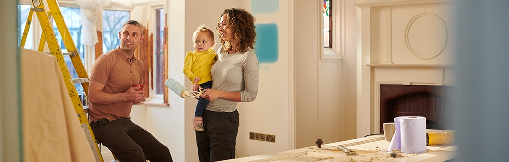 Una familia joven elige un nuevo color de pintura para su sala.