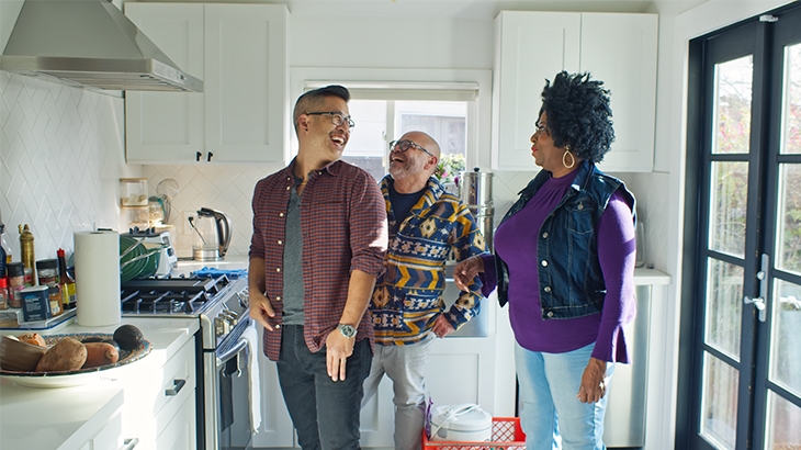 Family talking and laughing in the kitchen.