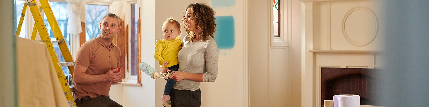 Una familia joven elige un nuevo color de pintura para su sala.