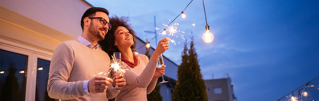 Couple celebrating New Year's with a sparkler.