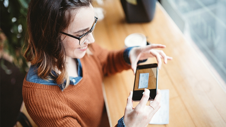 Woman taking a photo of a check for mobile deposit.