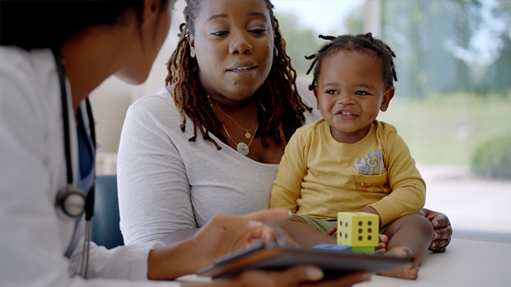 Mother and baby playing with blocks in doctors office.