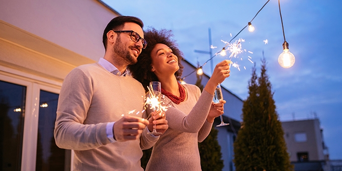 Couple celebrating New Year's with a sparkler.