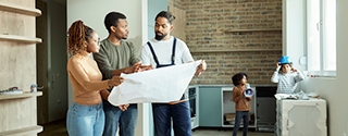 Couple looking at blueprints with contractor while kids play.