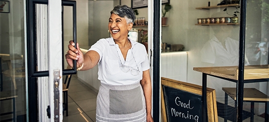 Feliz dueña de un café abre su tienda por la mañana.