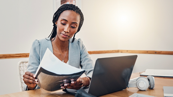 Woman with business documents sitting at desk.