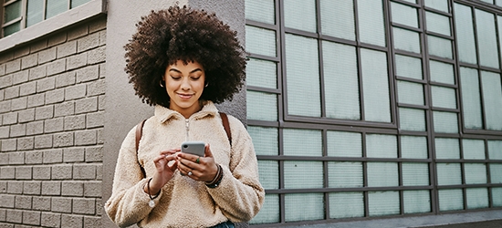 A young woman using WaFd Bank mobile app on her mobile phone.