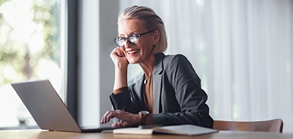 Business woman with laptop at desk in office.