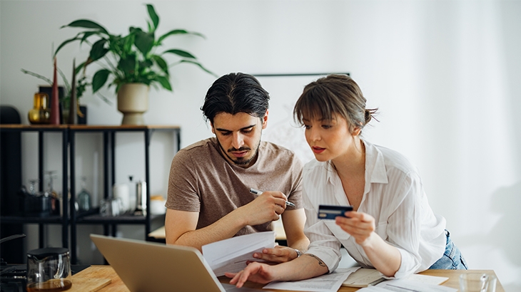 Couple paying bills on laptop.