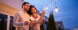 Couple celebrating New Year's with a sparkler.