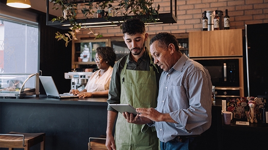 Business owner and employee looking at a tablet.