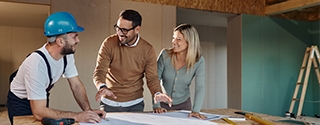 A couple with a contractor looking at their home remodeling plans.