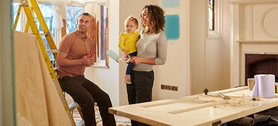 Una familia joven elige un nuevo color de pintura para su sala.