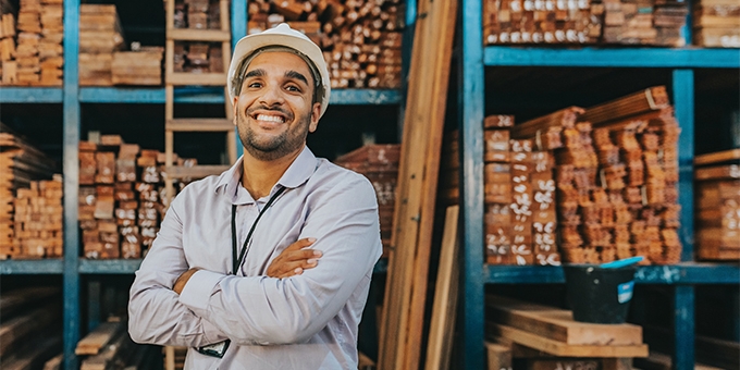 A man and woman working in a festive store that sells bright colorful gift wrapping supplies.